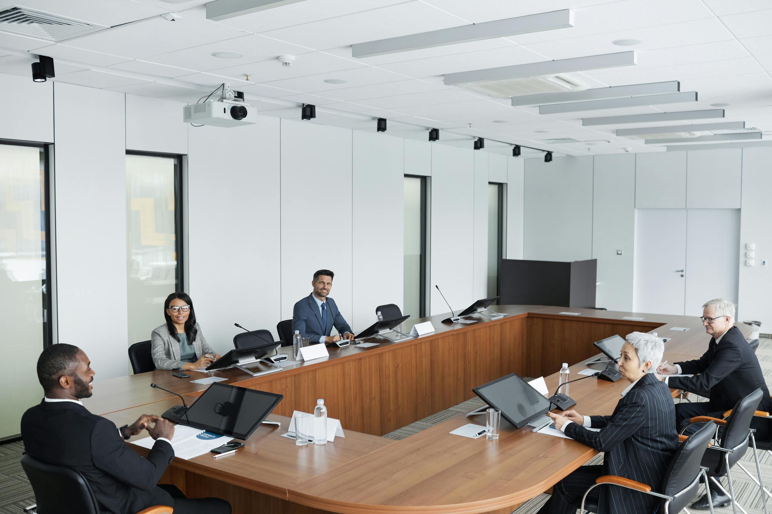 A multicultural group of professionals engaged in a business meeting in a modern conference room.